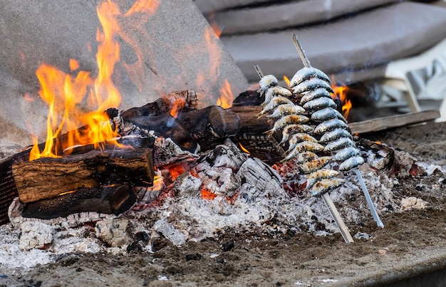 Foto un primer plano de algunos espetos cocinados en un fuego de leña