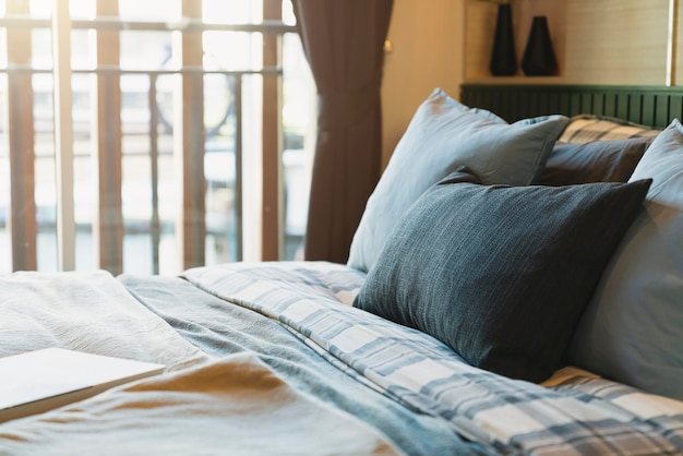 Primer plano de almohadas suaves de color beige blanco en la cama y el diseño de interiores del dormitorio de la manta concepto de ideas de lujo de mucama de cama