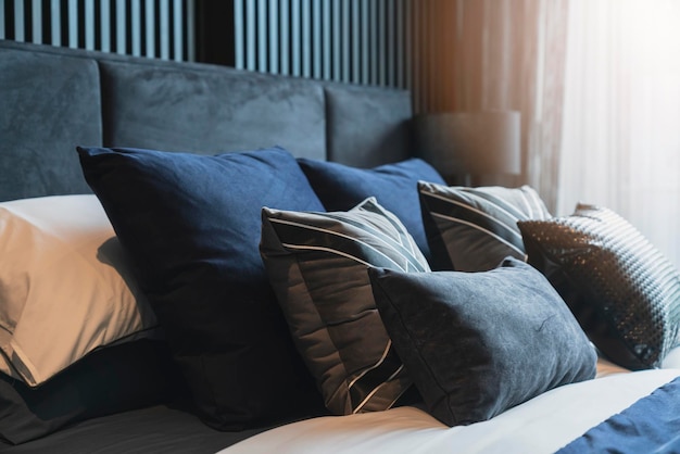 Primer plano de almohadas suaves de color beige blanco en la cama y el diseño de interiores del dormitorio de la manta concepto de ideas de lujo de mucama de cama