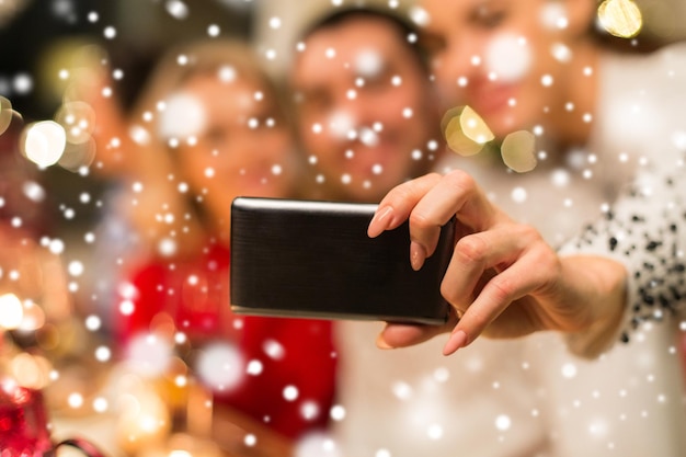 Foto un primer plano de amigos tomando selfies en navidad