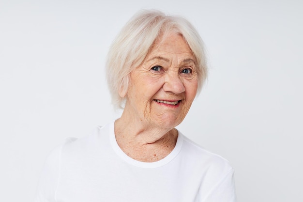 Primer plano de una anciana alegre en una camiseta blanca