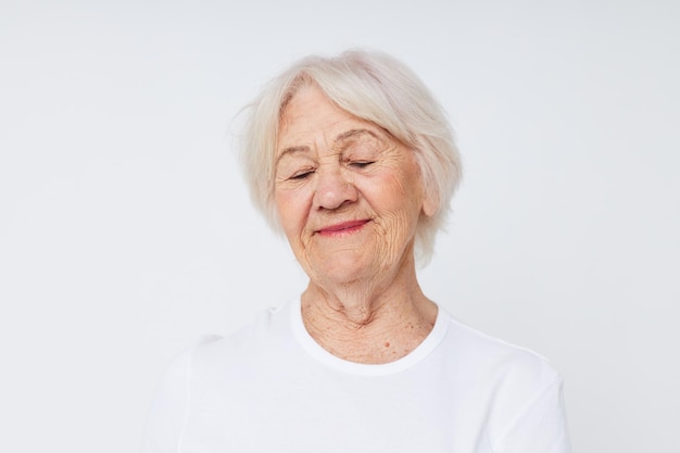 Primer plano de una anciana alegre en una camiseta blanca