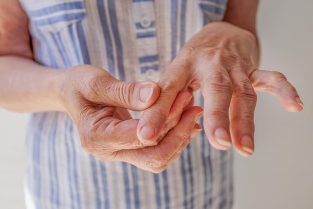 Primer plano una anciana se hace un masaje de manos artritis artrosis