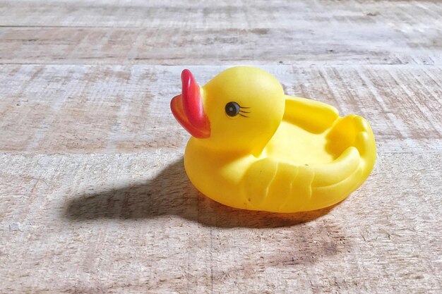 Foto primer plano de ángulo alto de un pato de goma en una mesa de madera