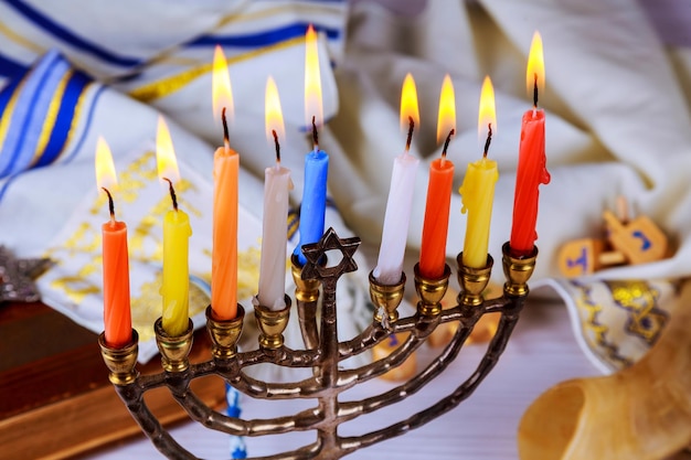 Primer plano de ángulo alto de velas de colores encendidas en una mesa de madera