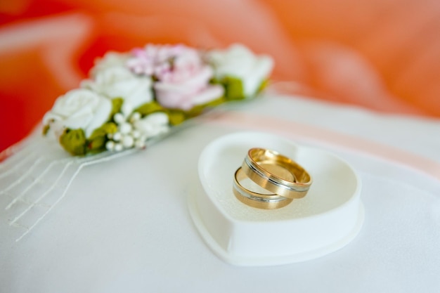 Primer plano de anillos de bodas en una caja de joyas en forma de corazón