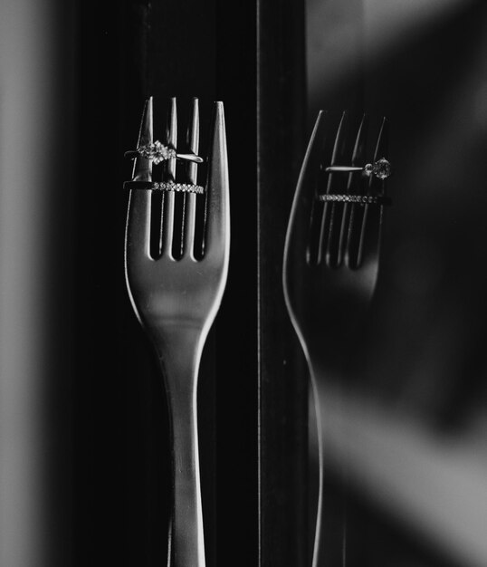 Primer plano de anillos de bodas en el tenedor con reflejo de la ventana