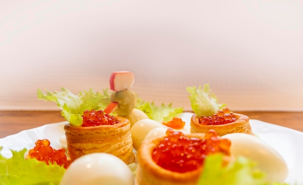 Primer plano de aperitivo de caviar y queso crema en galletas