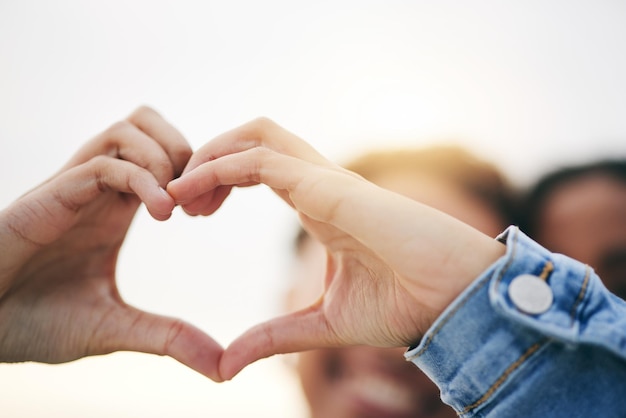 Primer plano de apoyo y pareja con las manos del corazón al aire libre y relación con el crecimiento, la salud y el icono Zoom personas y amantes con símbolo de cuidado romántico y felicidad con gesto y solidaridad