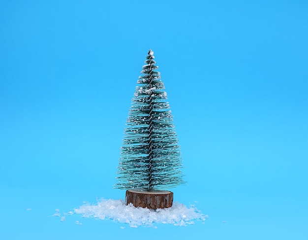 Primer plano de un árbol de Navidad artificial contra un fondo azul