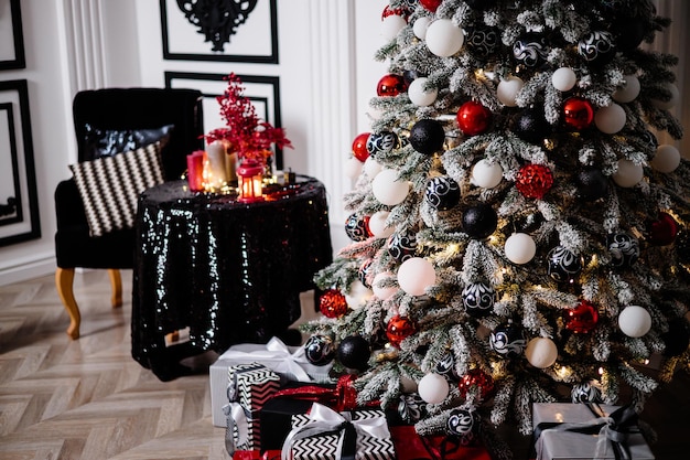 Primer plano del árbol de Navidad decorado. Bolas rojas y blancas y guirnaldas de luces con linternas. Decoraciones navideñas de vacaciones de invierno