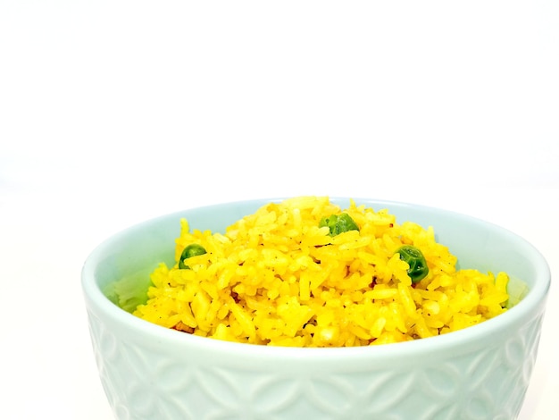 Primer plano de arroz en un cuenco contra un fondo blanco