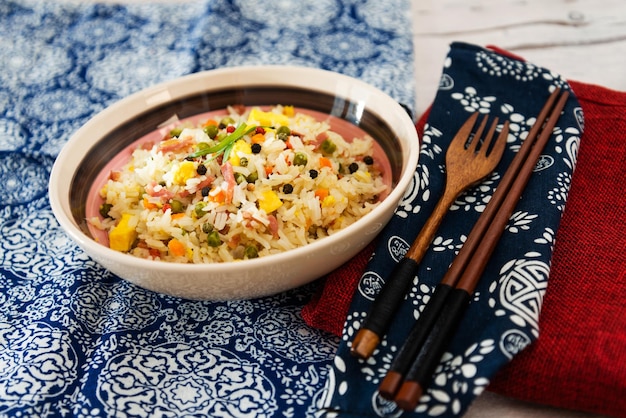 Primer plano de arroz en un cuenco en una mesa azul con patrones