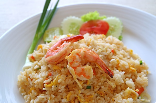 Primer plano de arroz frito estilo tailandés con camarones o Khao Pad Goong servido en un plato blanco de cerámica