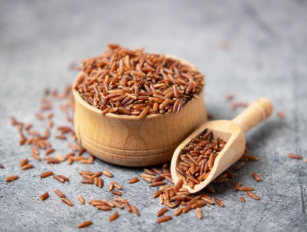 Primer plano de arroz integral en un tazón de madera y una cuchara