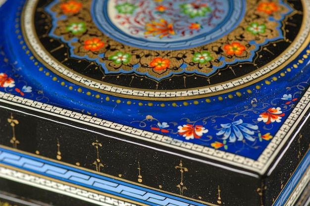 Un primer plano de un ataúd con una pintura artística sobre un fondo negro Asia Central Uzbekistán
