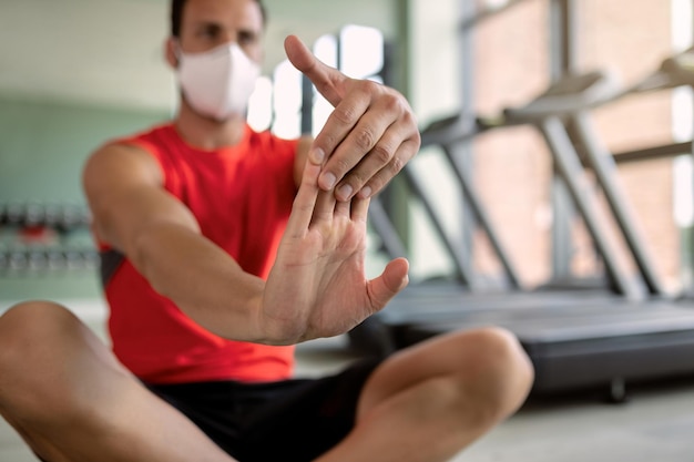 Primer plano de atleta haciendo ejercicios de estiramiento en un gimnasio