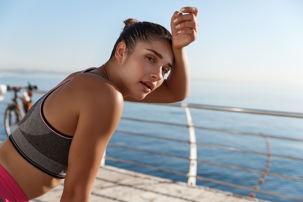 Primer plano de la atractiva deportista tomando un respiro durante el entrenamiento