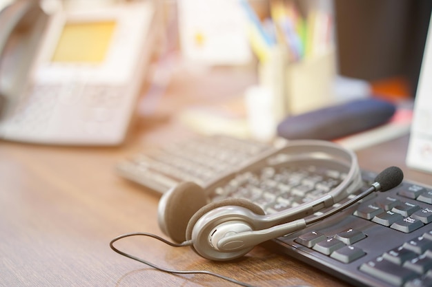 Foto primer plano de los auriculares en el teclado en el escritorio de la oficina