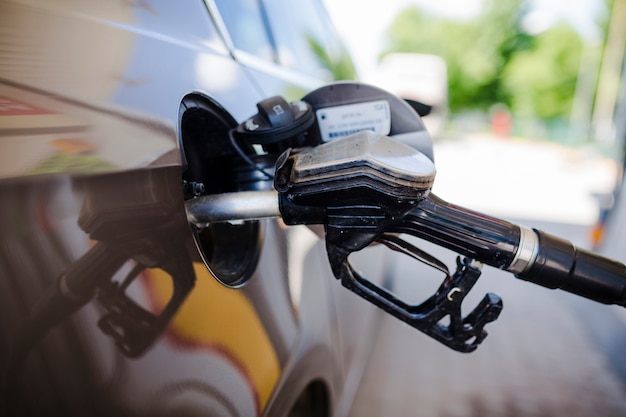 Foto primer plano de un automóvil de reabastecimiento de combustible en la estación de servicio