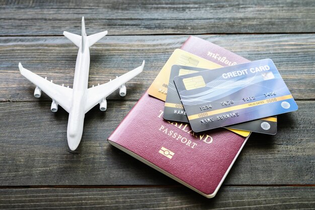 Foto primer plano de un avión de juguete con tarjeta de crédito y pasaporte en la mesa