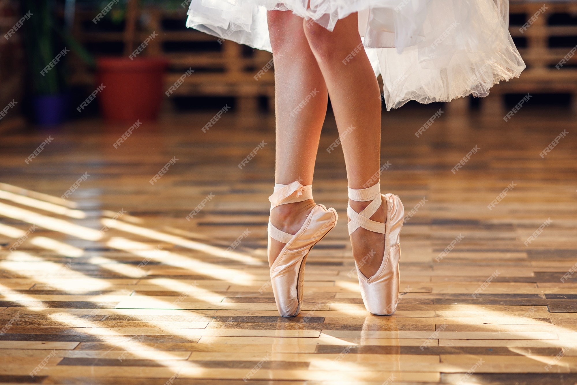 Primer plano bailando piernas de bailarina con zapatillas de punta blanca en el salón de baile. Foto Premium