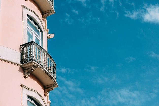 Primer plano de un balcón de un edificio rosa en Lisboa Portugal