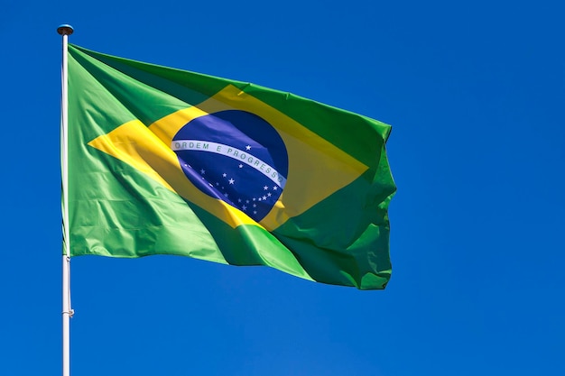 Primer plano de la bandera de Brasil ondeando en la cima de su poste