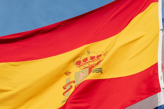 Foto primer plano de la bandera de españa ondeando en el cielo azul