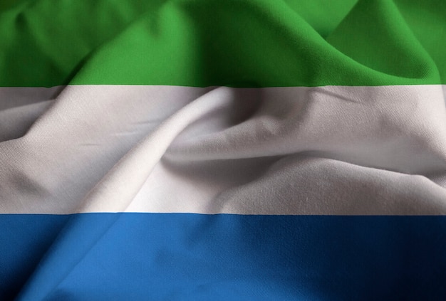 Primer plano de la bandera de Sierra Leona con volantes, bandera de Sierra Leona soplando en el viento