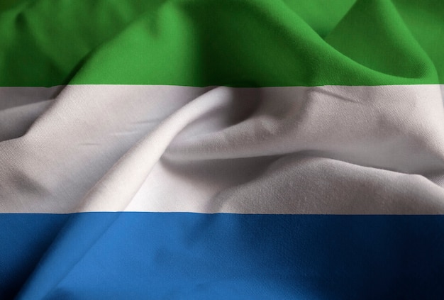 Foto primer plano de la bandera de sierra leona con volantes, bandera de sierra leona soplando en el viento