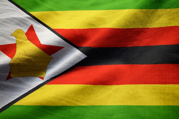 Primer plano de la bandera de zimbabwe con volantes, bandera de zimbabwe que sopla en el viento