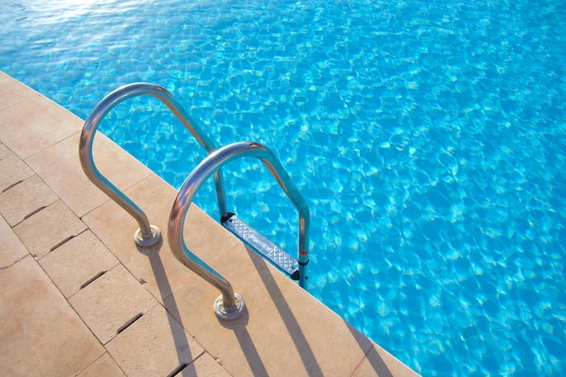 Primer plano de la barandilla de acero inoxidable de la piscina que desciende hacia el agua clara de la piscina de tortuga Accesibilidad del concepto de actividades recreativas