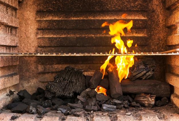 Primer plano de barbacoa parrilla con briquetas de carbón caliente