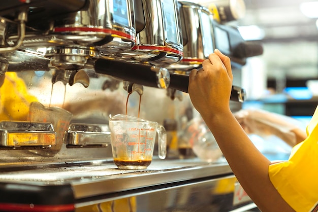 Primer plano de barista trabajando haciendo café con máquina de café imagen tono de color abstracto desenfoque de fondo