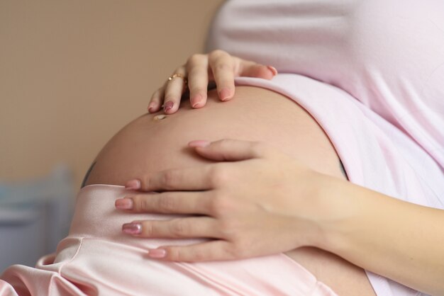 Foto primer plano barriga de mujer embarazada con las manos