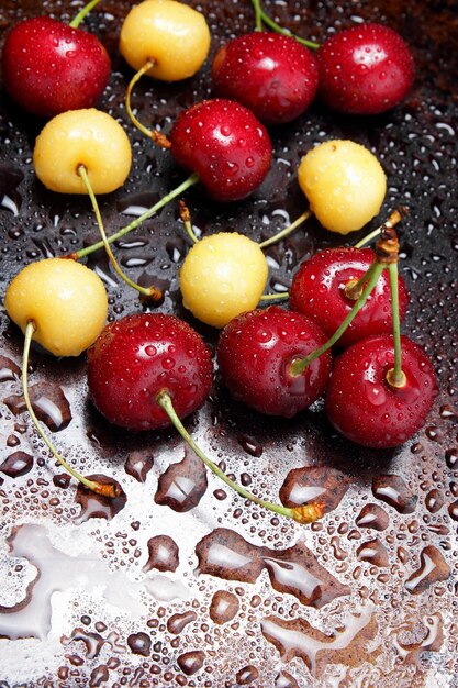 Primer plano de bayas de cereza frescas con gotas de agua Composición de cerezas dulces sobre un fondo oscuro con vista superior de gotas de agua