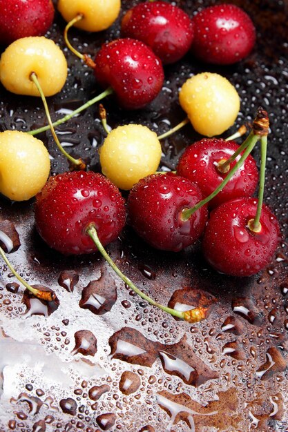 Primer plano de bayas de cereza frescas con gotas de agua Composición de cerezas dulces sobre un fondo oscuro con vista superior de gotas de agua