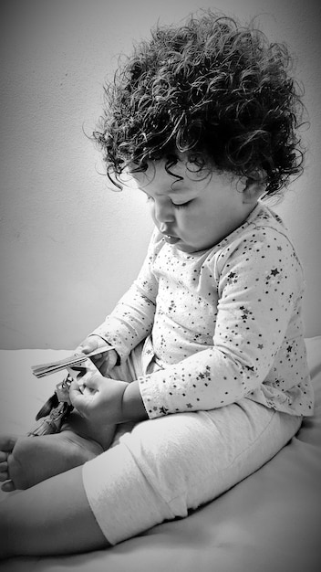 Primer plano de un bebé jugando con un juguete en la cama