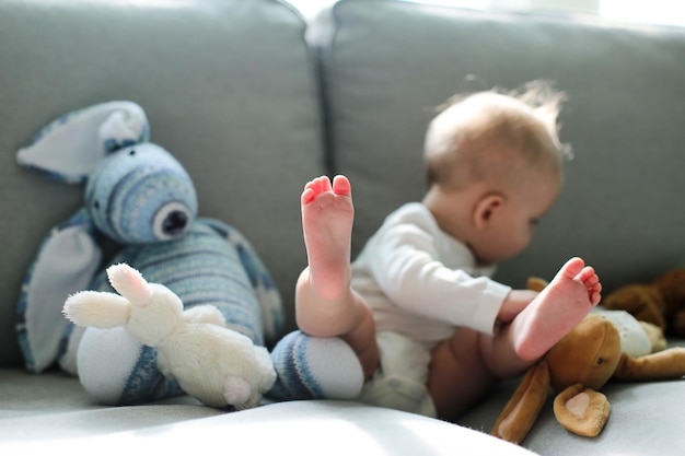 Primer plano de un bebé jugando con juguetes de peluche en casa