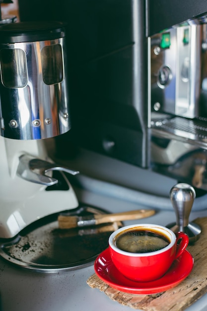 Foto primer plano de la bebida por la cafetera en la mesa