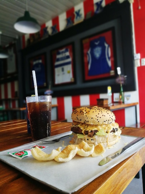 Primer plano de la bebida y la hamburguesa en la mesa