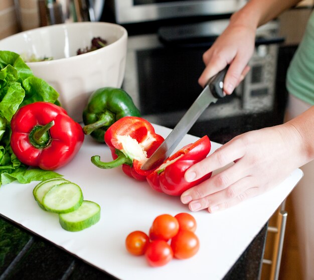 Primer plano de una bella mujer preparando una ensalada