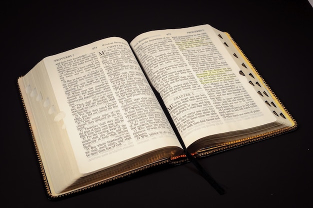 Primer plano de la Biblia contra un fondo negro