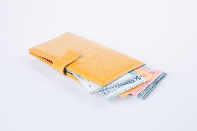 Foto primer plano de una billetera con dinero en fondo blanco