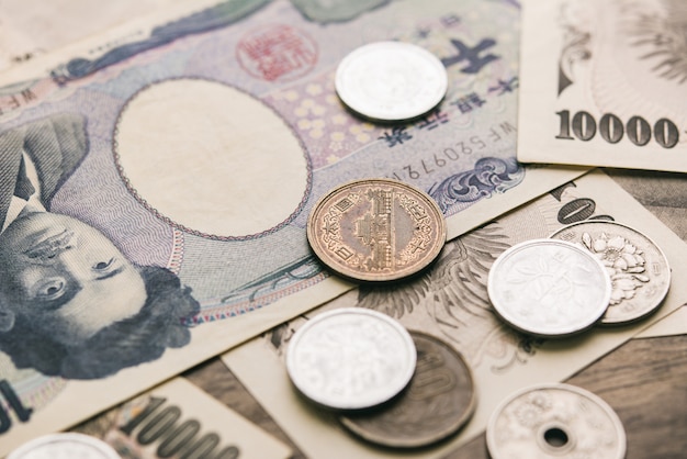 Foto primer plano de billetes y monedas de dinero yen japonés sobre la mesa