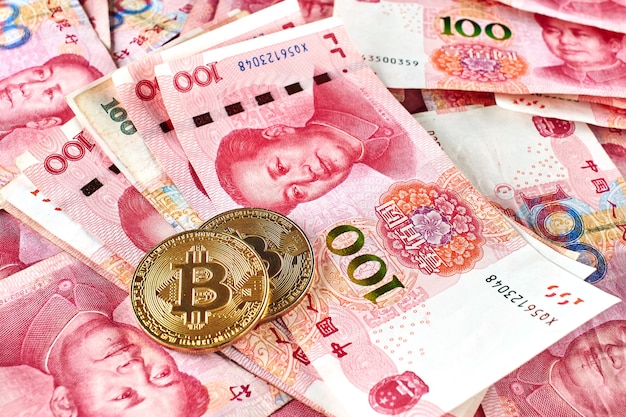 Primer plano de Bitcoin y dinero de Yuan chino. Concepto de inversión en moneda virtual digital de internet