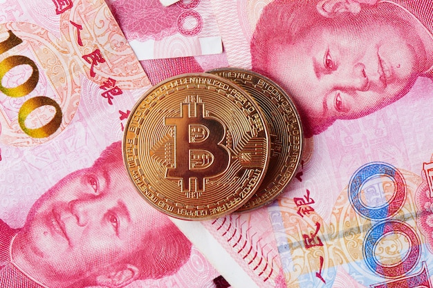 Primer plano de Bitcoin y dinero de Yuan chino. Concepto de inversión en moneda virtual digital de internet