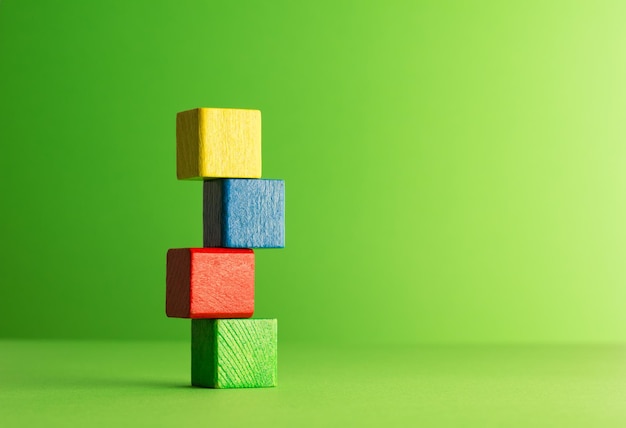 Primer plano de bloques de juguete de colores contra un fondo verde