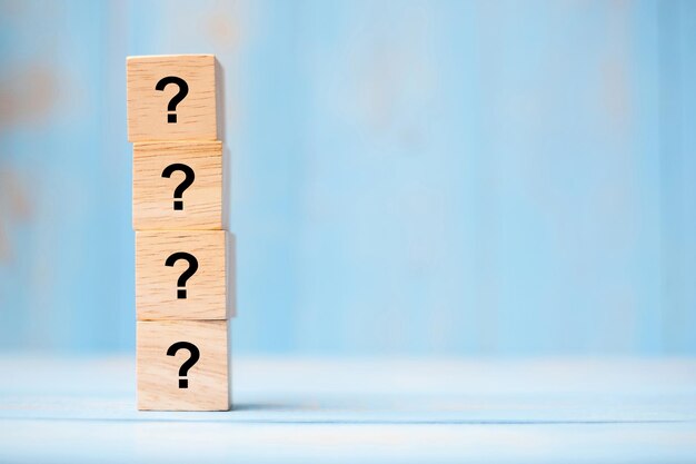 Primer plano de los bloques de juguete con signos de interrogación en la mesa